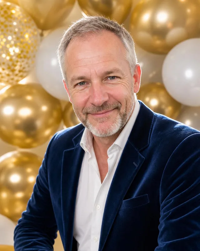 AI birthday photo: man in a navy velvet blazer in front of gold and white balloons