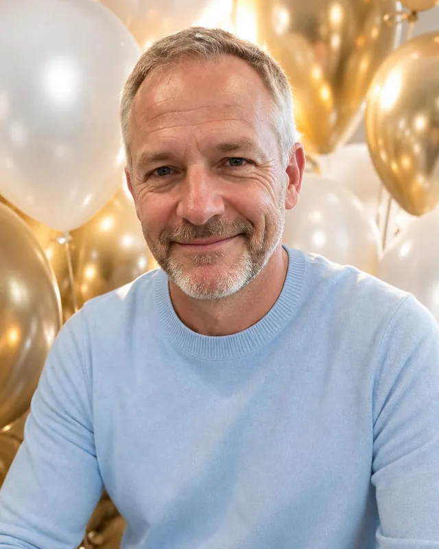 AI birthday photo: man in a pastel blue sweater in front of gold and white balloons